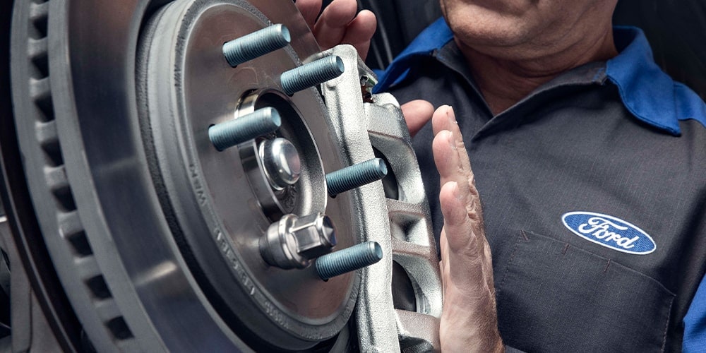 Ford service technician installing a brake rotor