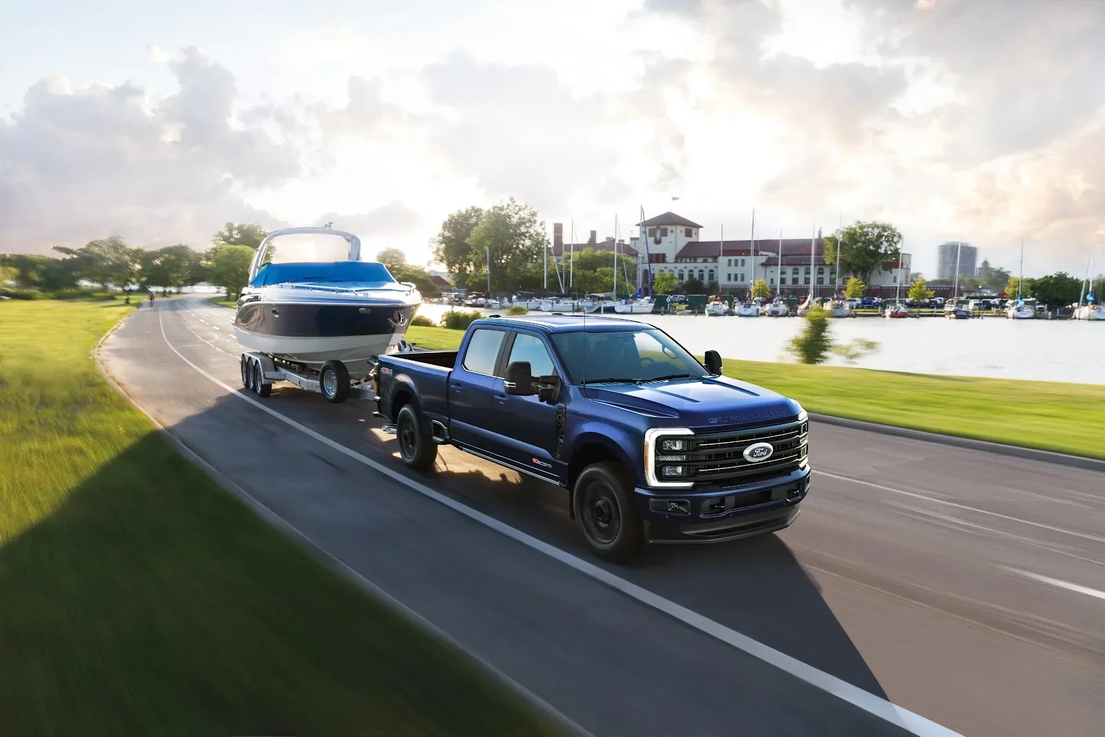 2026 Ford F-350 Super Duty Platinum in Argon Blue towing a boat, seen from the right front